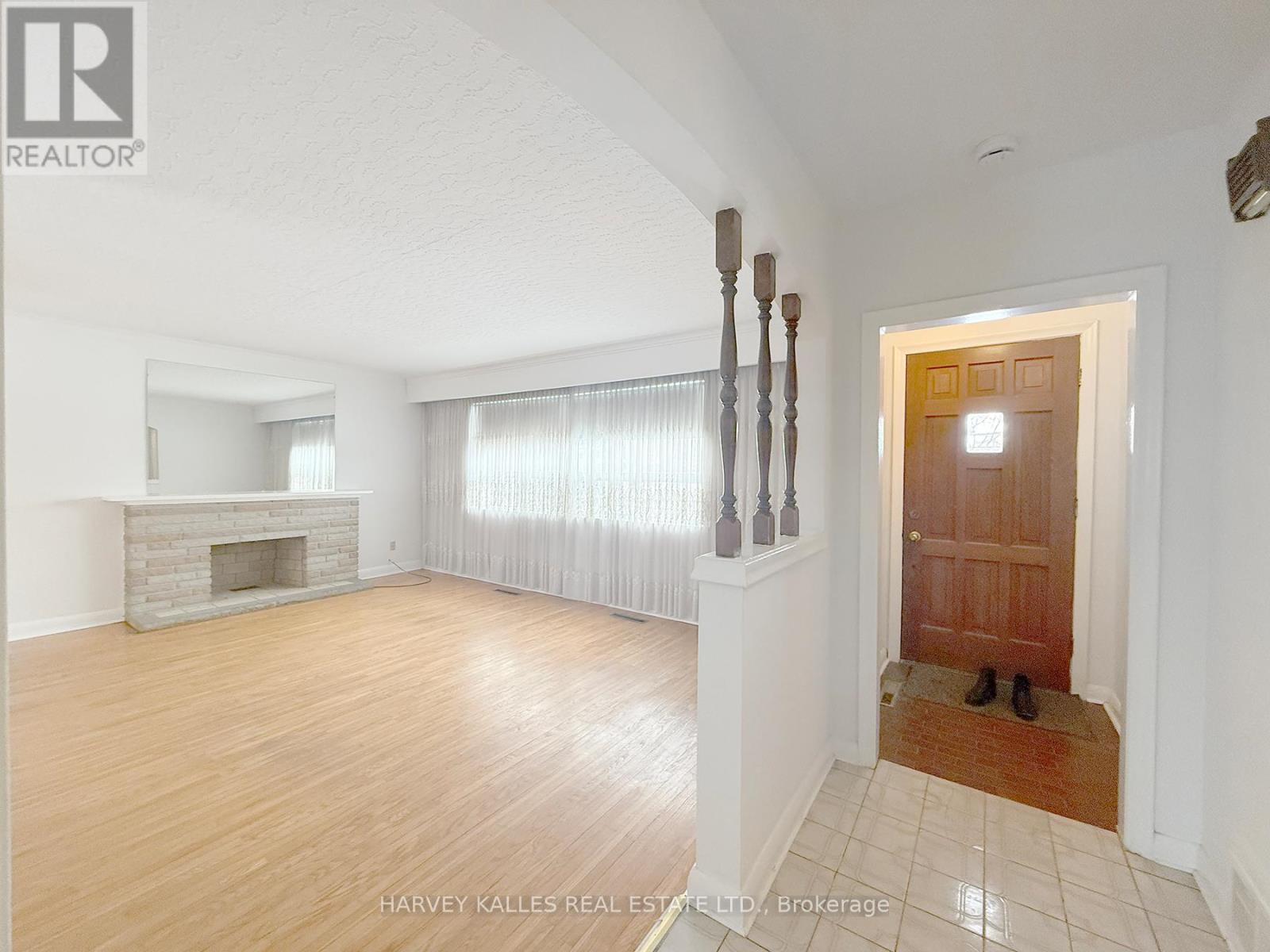 A spacious room with a fireplace and a pair of shoes by the door.
