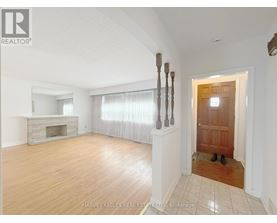 A spacious room with a fireplace and a pair of shoes by the door.