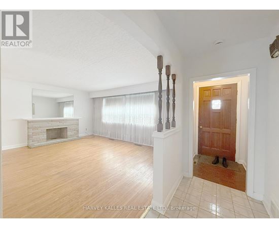 A spacious room with a fireplace and a pair of shoes by the door.