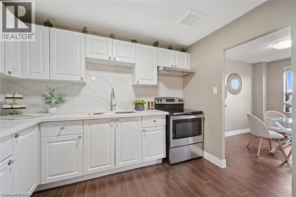 A kitchen with white cabinets and a wooden floor.