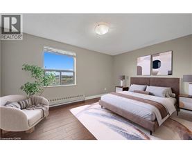 A bedroom with a large bed and a chair.