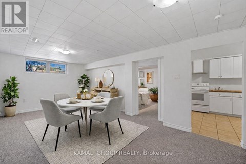 A dining room with a table set for four and a kitchen in the background.