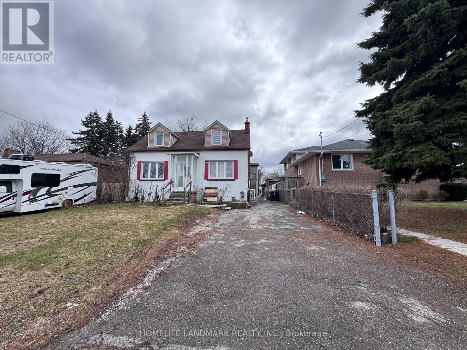 A realtor image of a house with a driveway and a white RV parked in front.