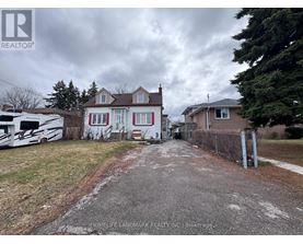 A realtor image of a house with a driveway and a white RV parked in front.