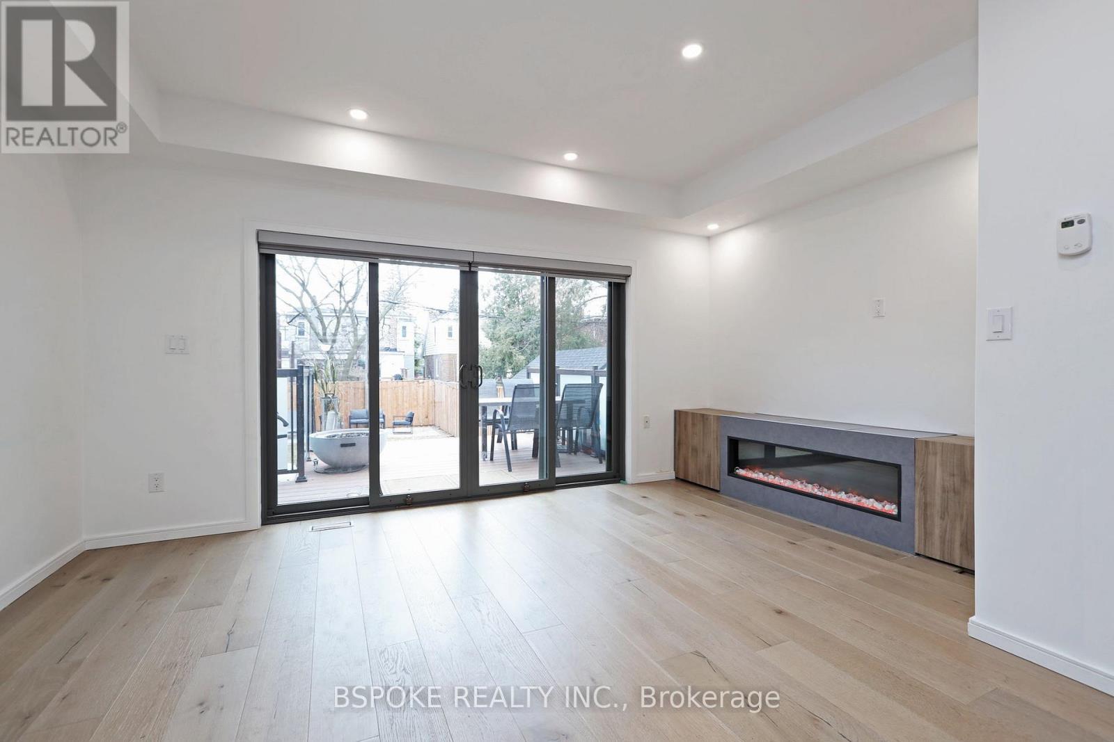 A spacious room with a fireplace and sliding glass doors leading to a patio.