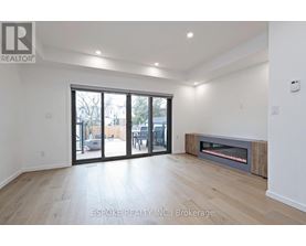 A spacious room with a fireplace and sliding glass doors leading to a patio.