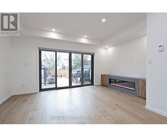A spacious room with a fireplace and sliding glass doors leading to a patio.