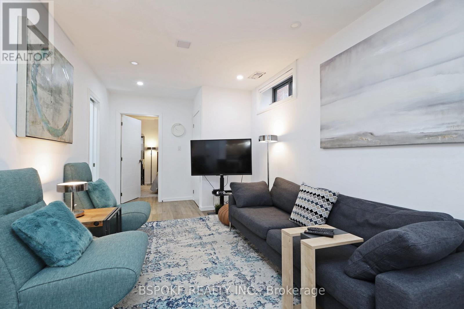 A living room with a grey couch and a blue rug.