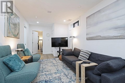 A living room with a grey couch and a blue rug.