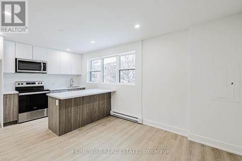 A modern kitchen with wooden cabinets and a stainless steel oven.