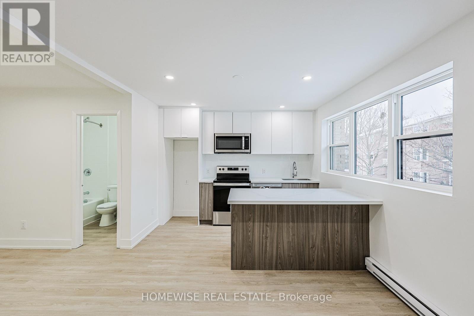 A modern kitchen with white cabinets and a wooden island.
