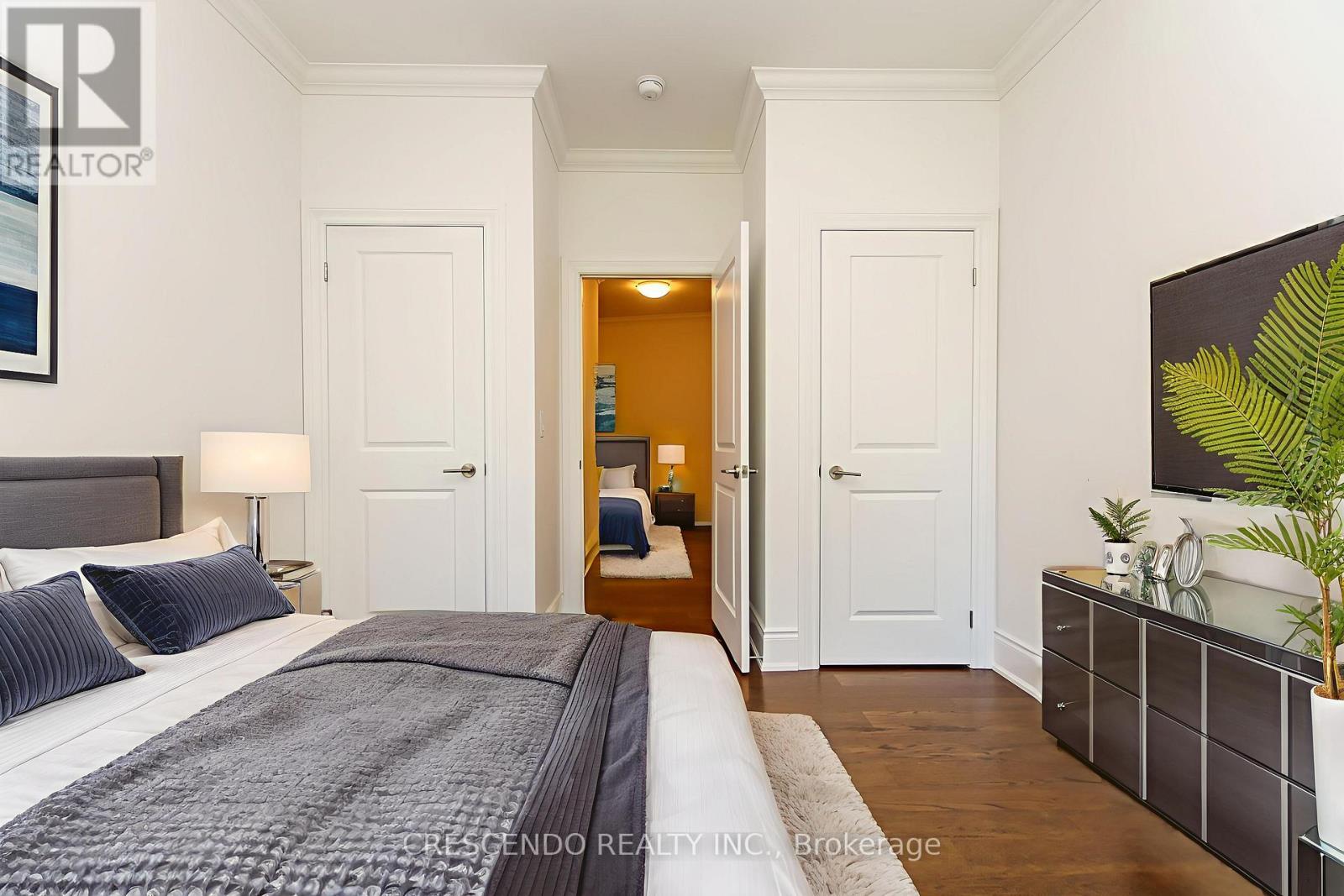A bedroom with a large bed and a TV on the wall.