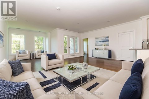 A living room with white furniture and a glass coffee table.