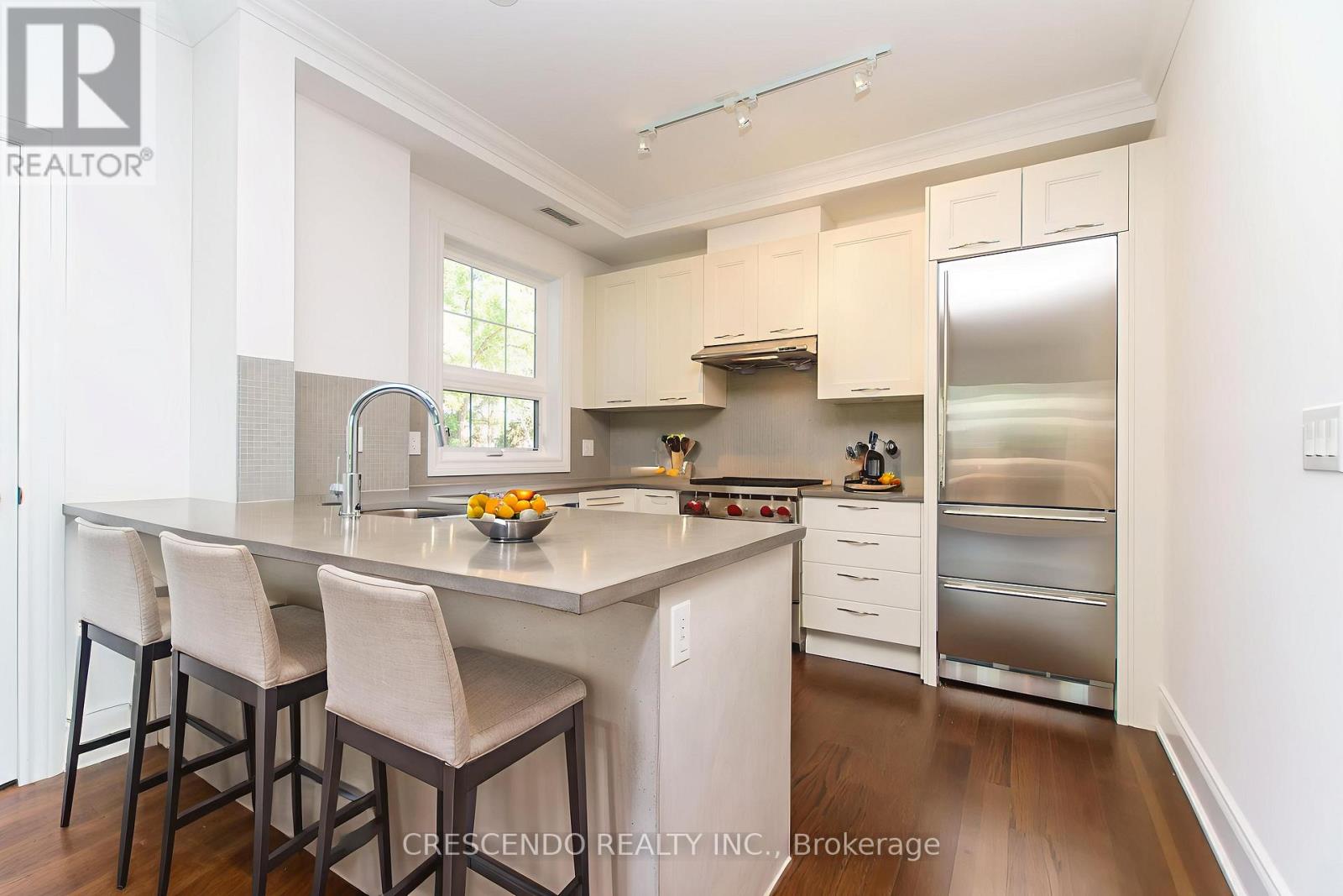A modern kitchen with white cabinets and stainless steel appliances.