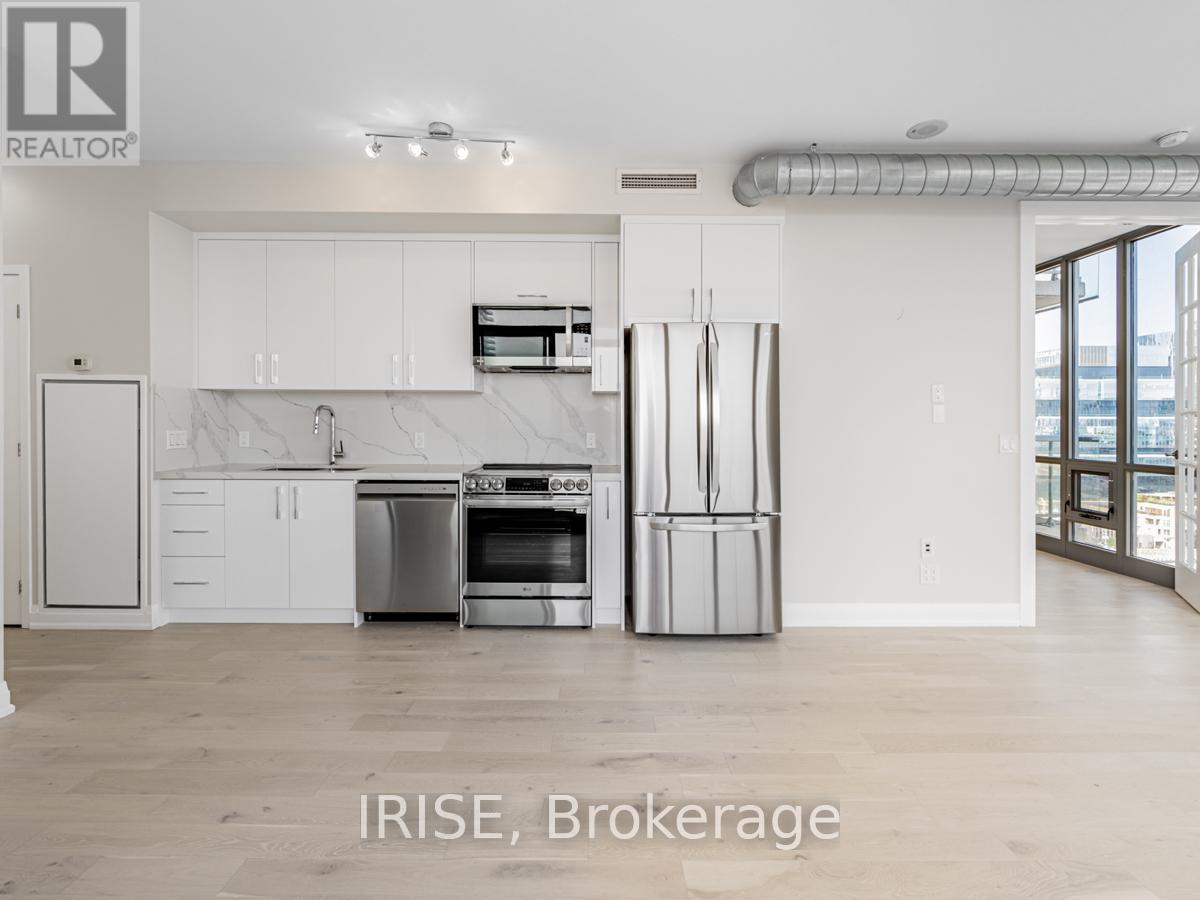 A kitchen with white cabinets and a marble countertop.
