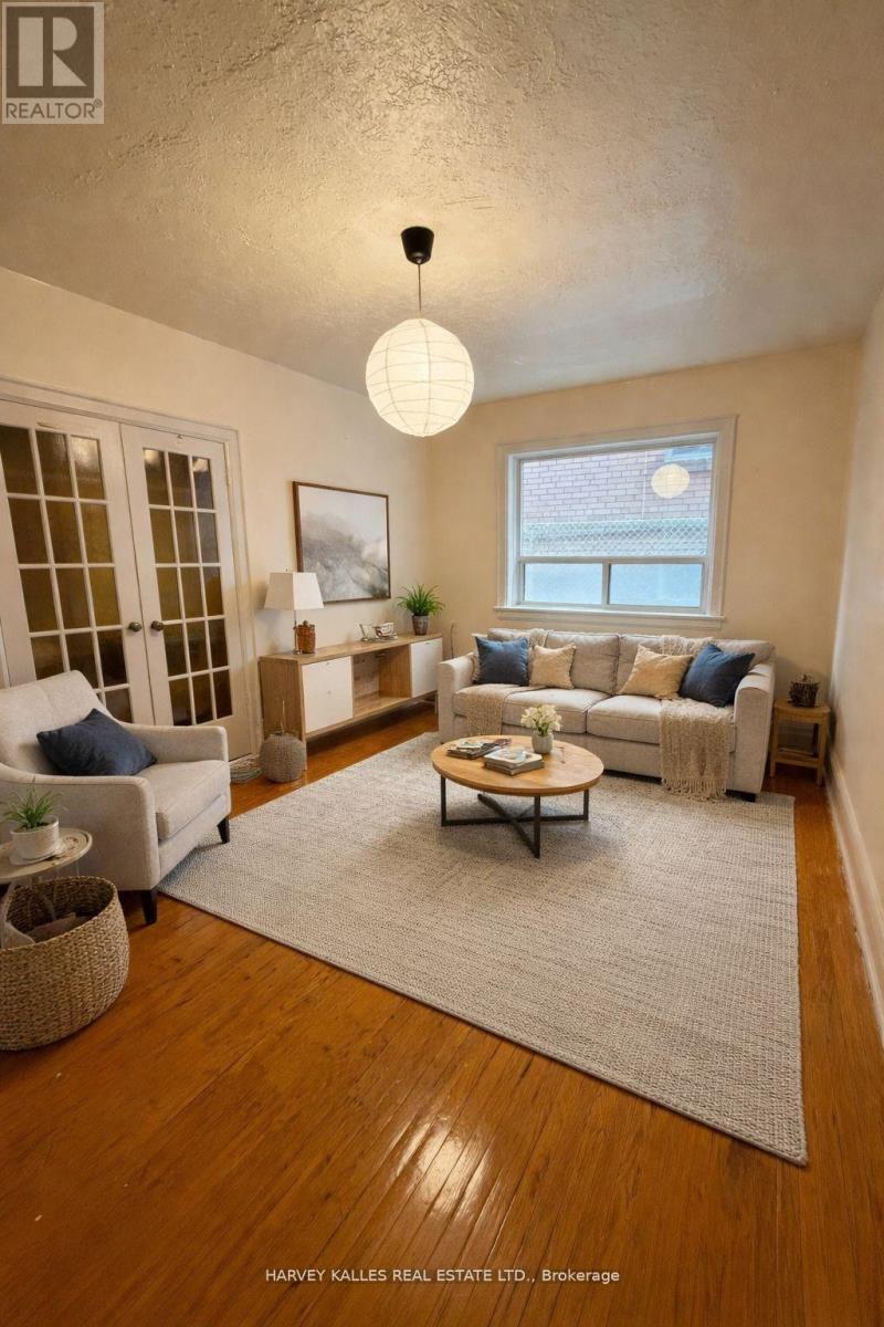 A well-lit living room with a couch, chair, and rug.