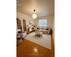 A well-lit living room with a couch, chair, and rug.