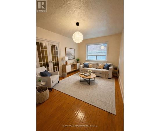 A well-lit living room with a couch, chair, and rug.
