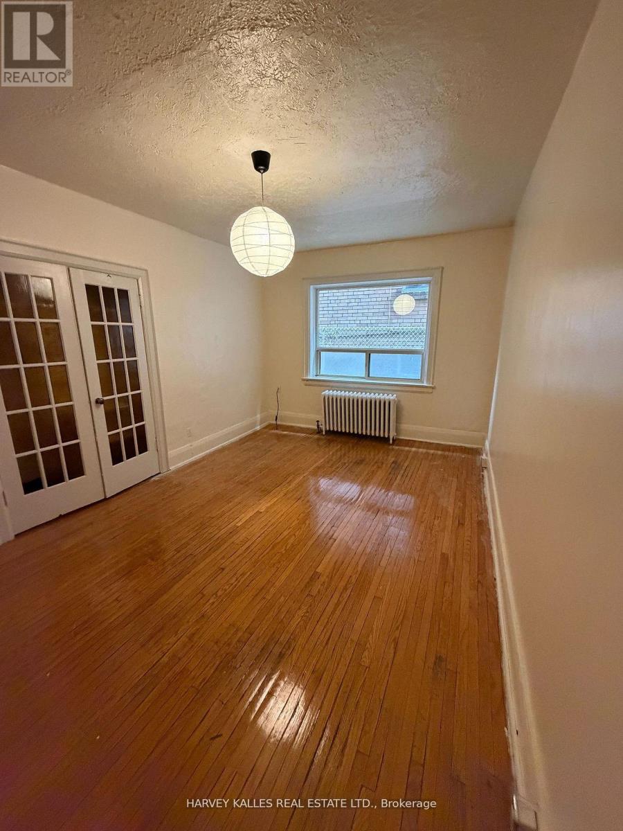 A room with wooden floors and a window with blinds.
