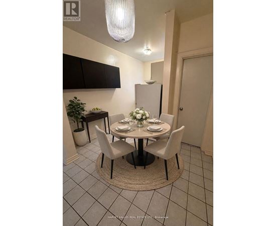 A dining room with a round table set for four.
