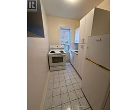 A kitchen with white appliances and cabinets.