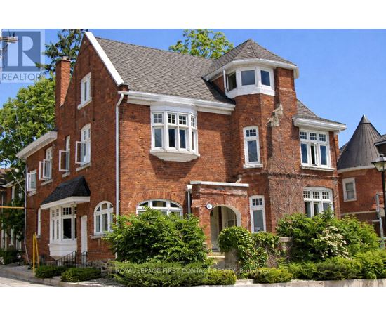 A large red brick house with a black roof and white windows.