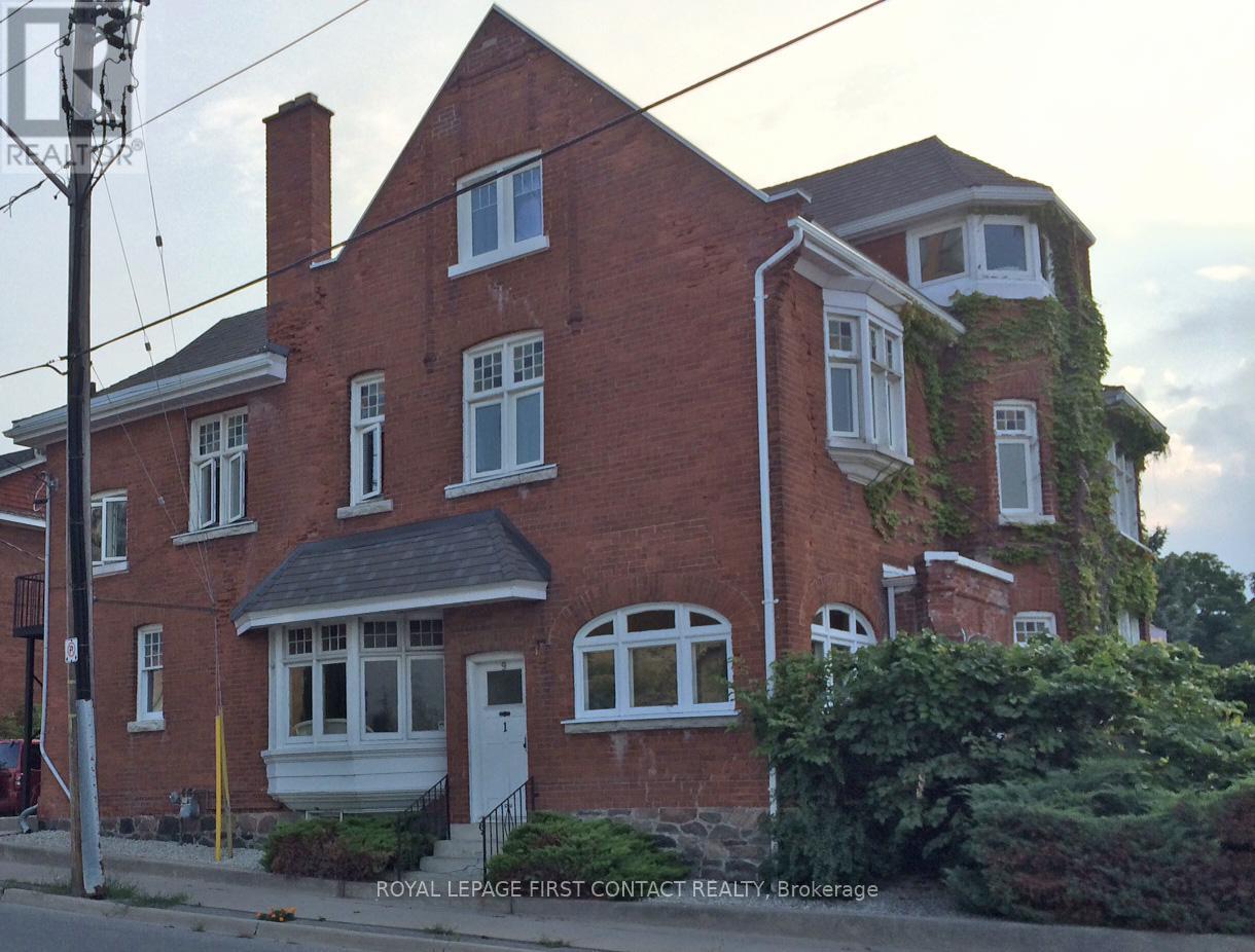 A red brick house with white trim and a white door.
