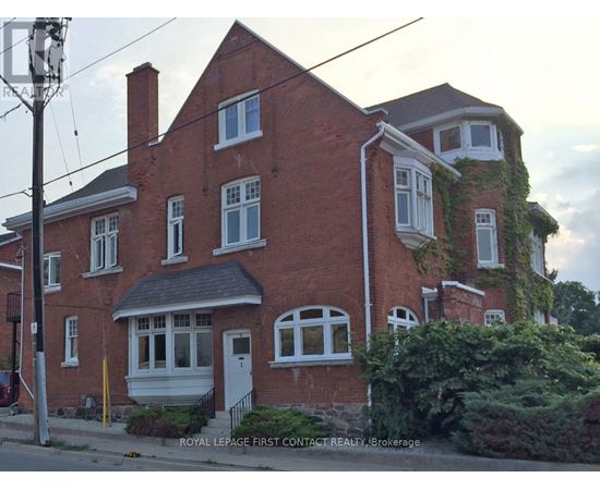 A red brick house with white trim and a white door.