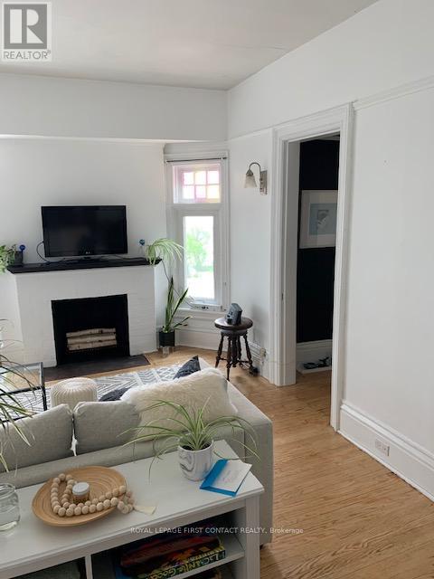 A living room with a fireplace and a television on the wall.