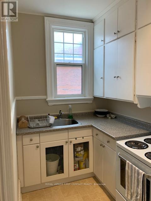 A kitchen with white cabinets and a window above the sink.