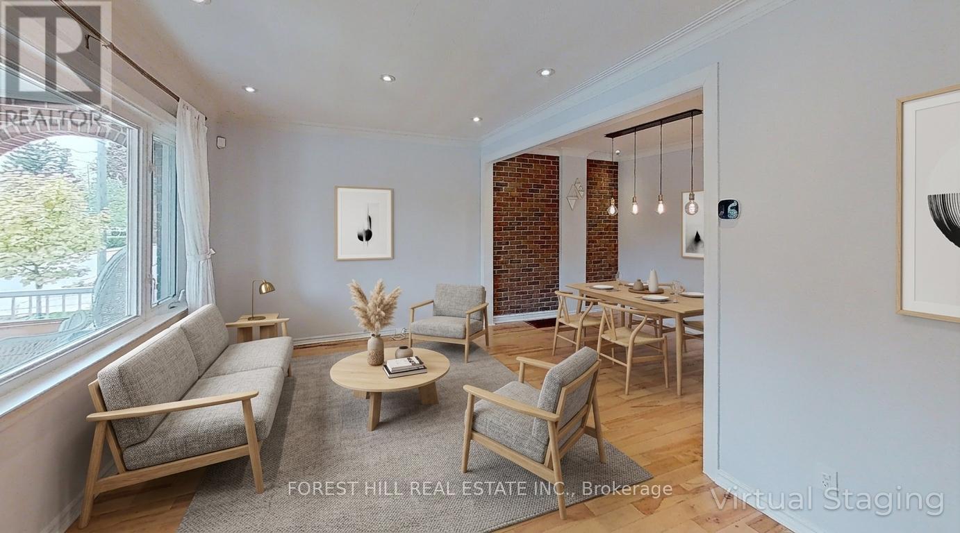 A living room with a grey sofa, wooden chairs and a coffee table.