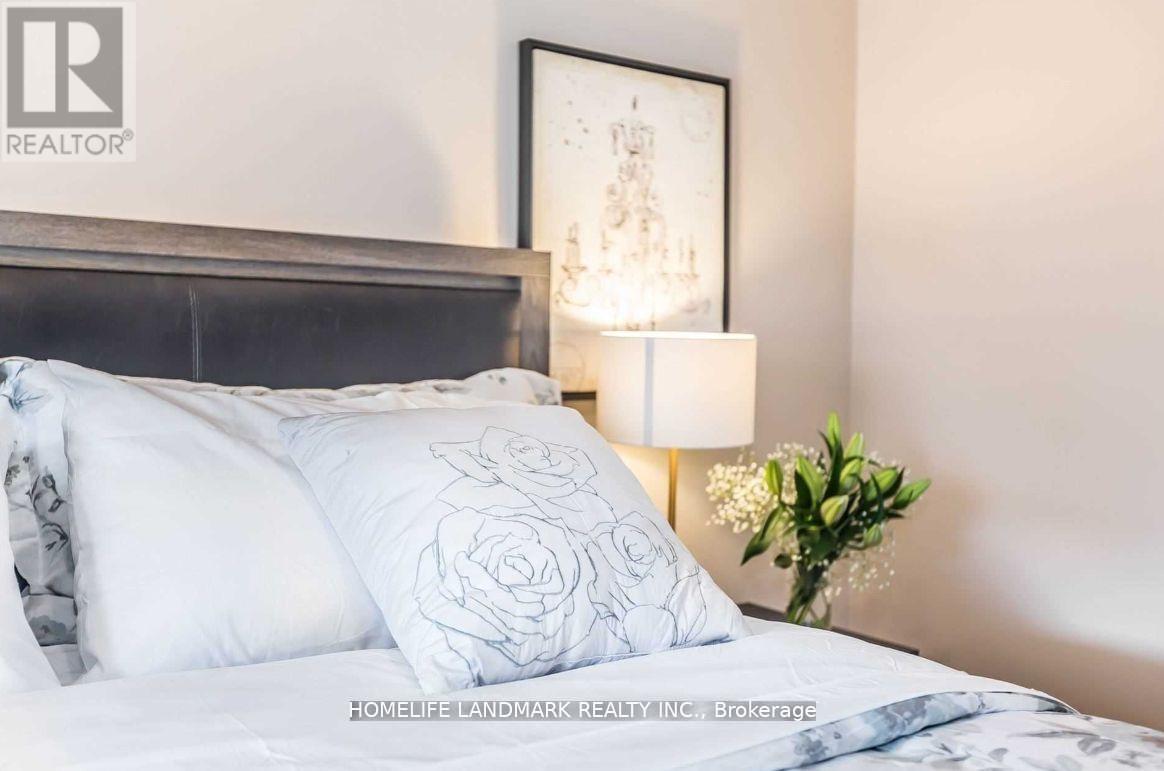 A bed with a white pillow that has a rose design on it.