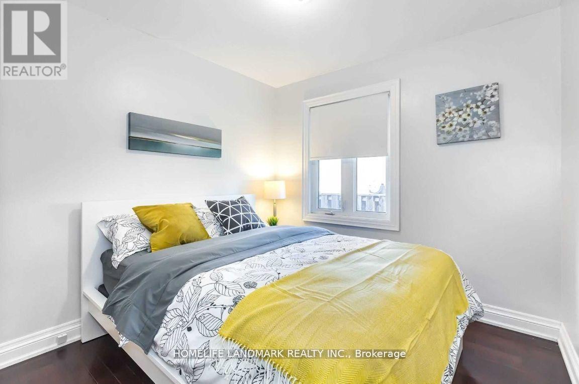 A bedroom with a bed covered in a yellow comforter and a white headboard.
