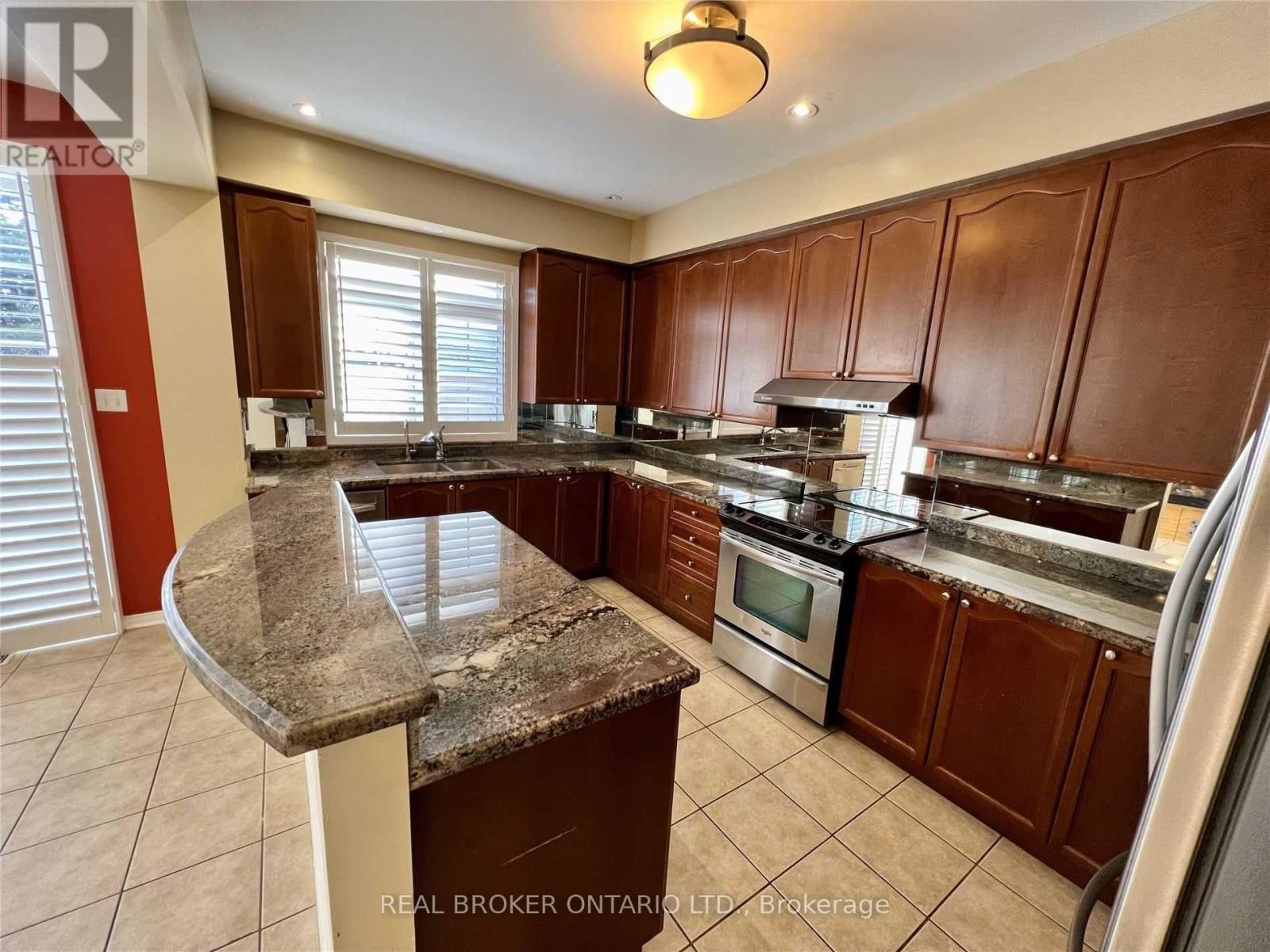 A kitchen with brown cabinets and a granite countertop.