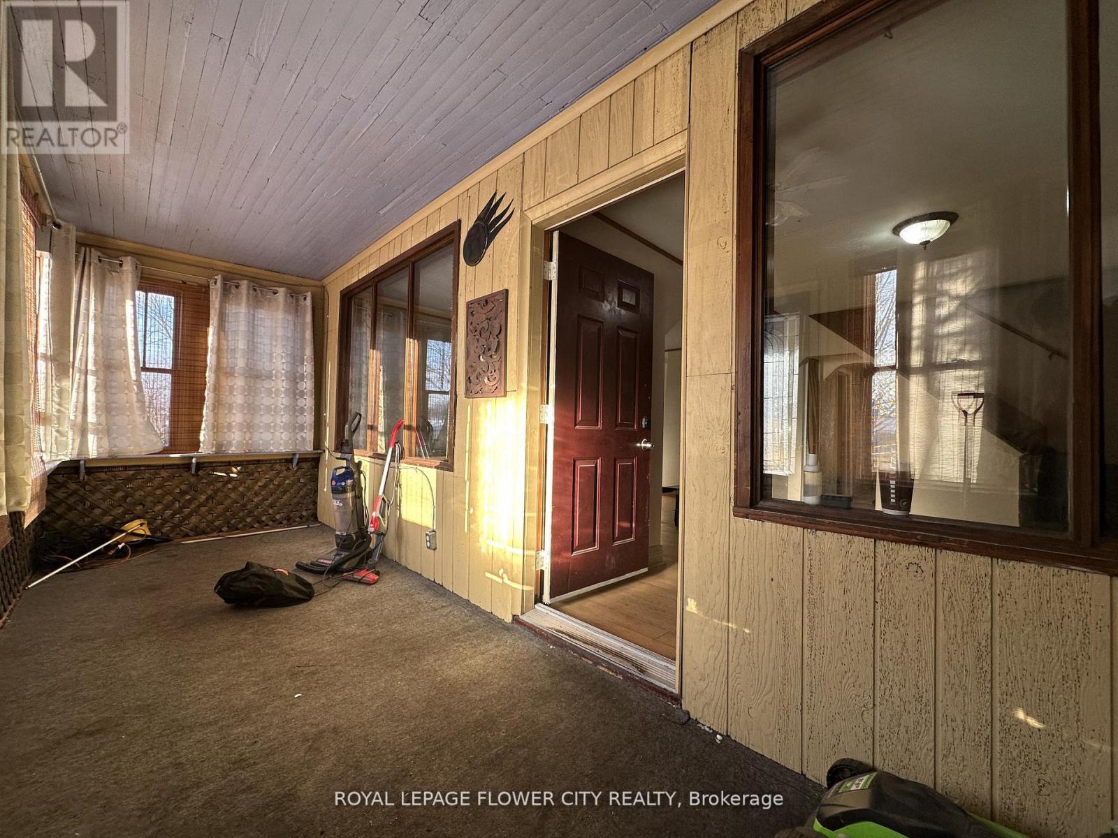 A room with a leather couch and a vacuum cleaner.