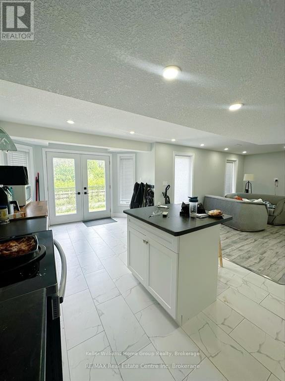 A modern kitchen with white cabinets and a black countertop.
