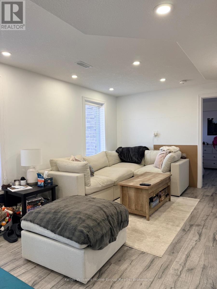 A living room with a white couch and a grey ottoman.