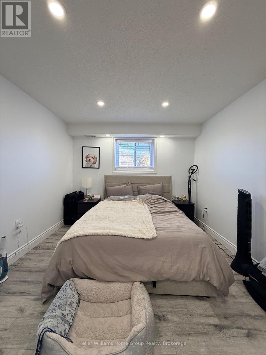 A bedroom with a bed, nightstand, and window.