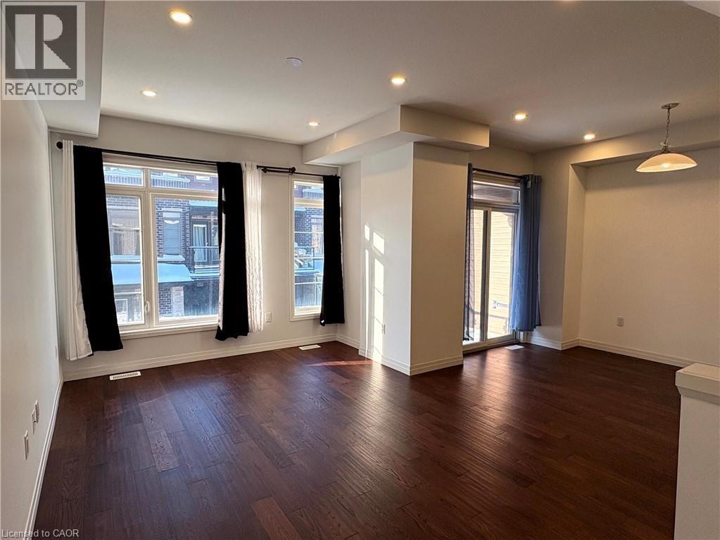 A spacious room with wooden floors and large windows.