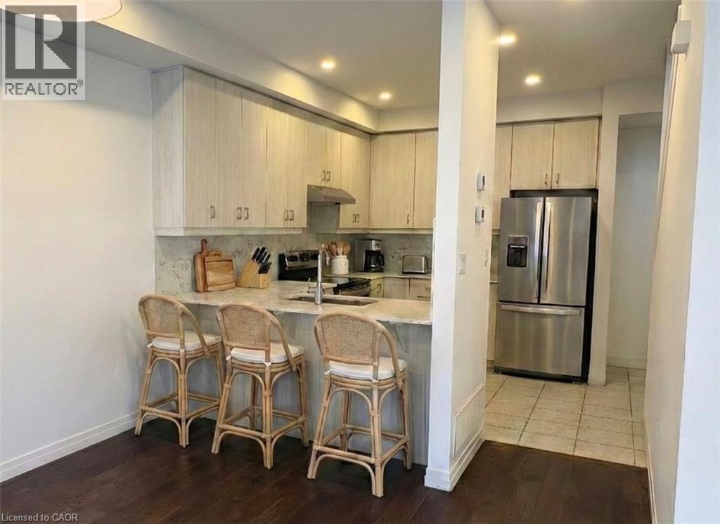 A kitchen with white cabinets and a refrigerator.