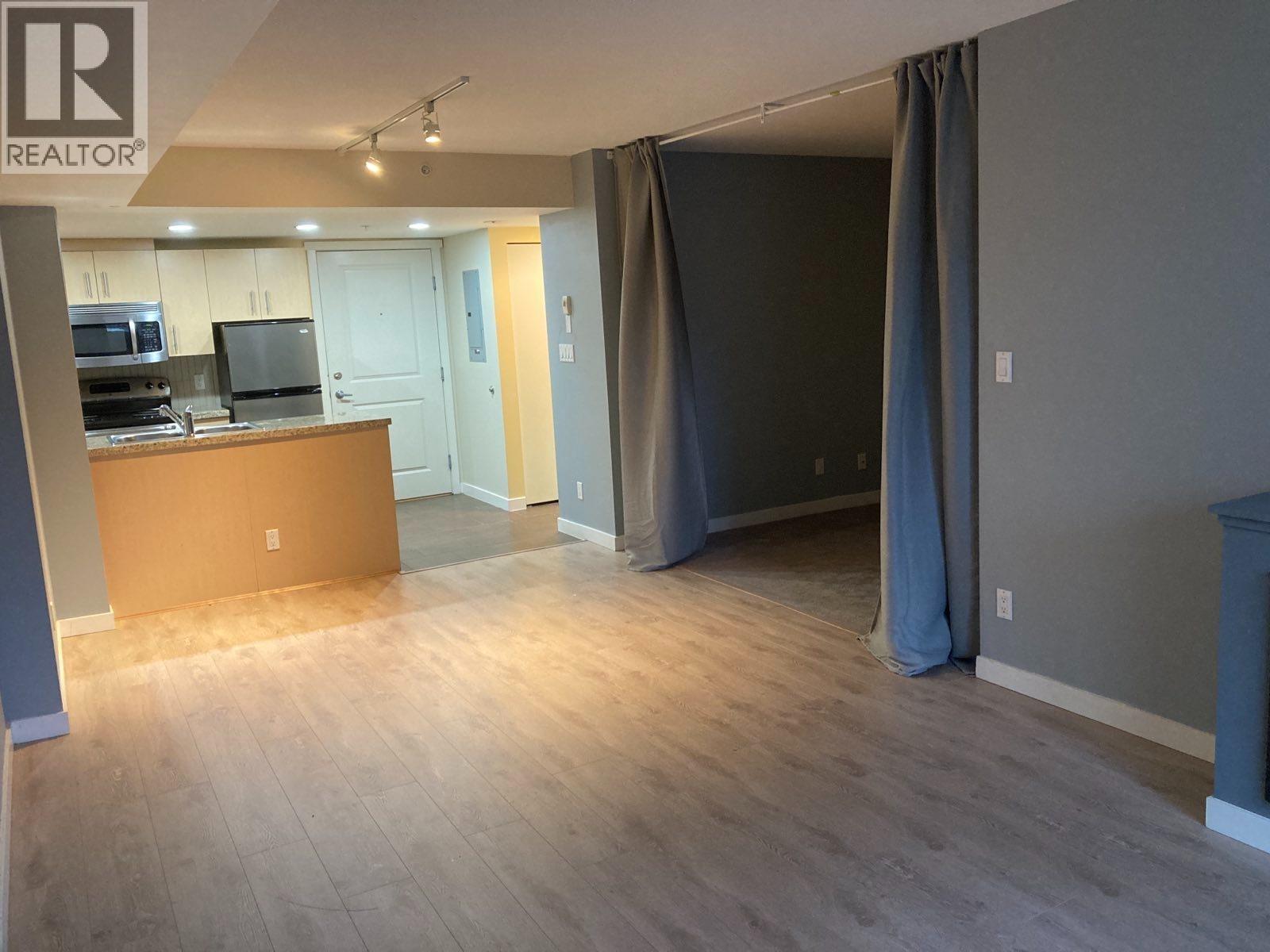 A room with a brown desk and a grey wall.