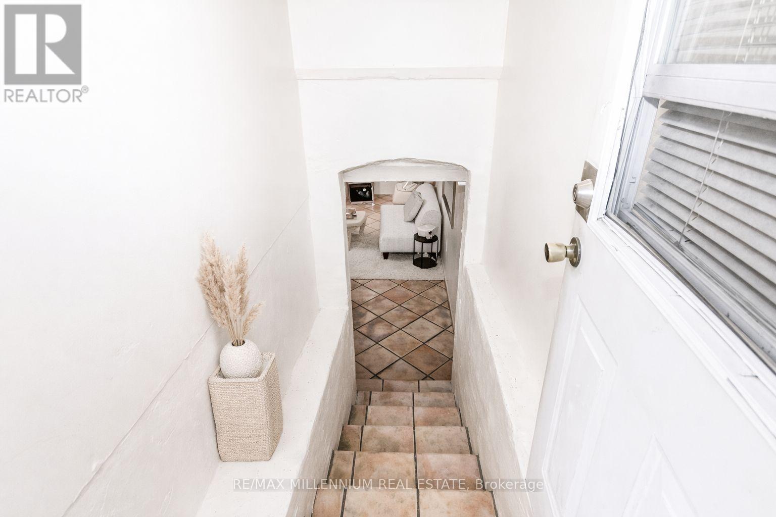 A hallway with a vase and a door.