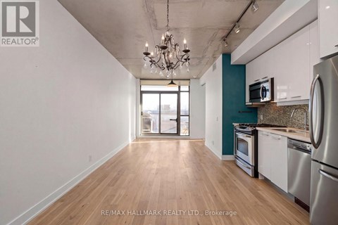A kitchen with white cabinets and a wooden floor.