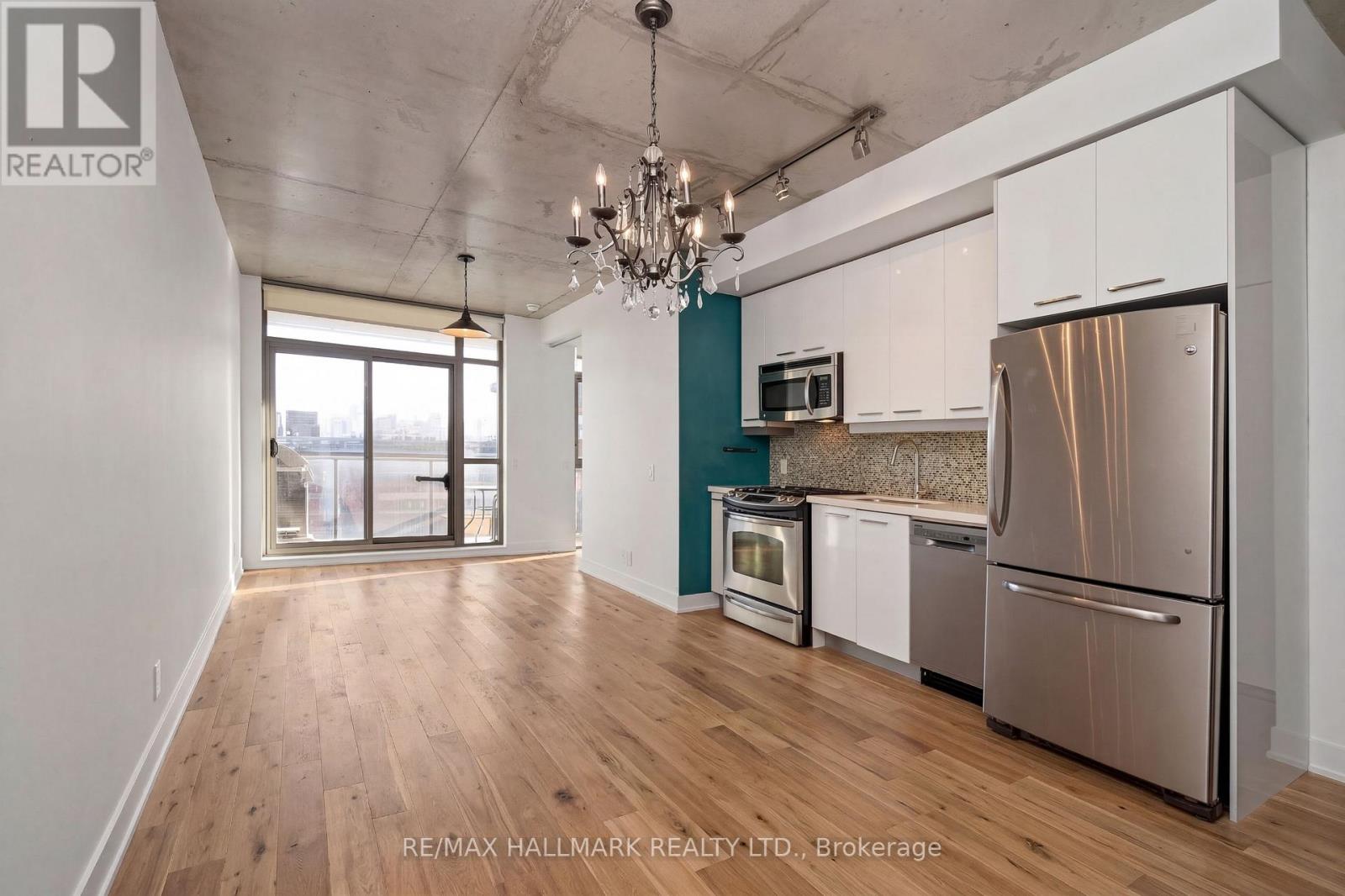 A kitchen with white cabinets and a stainless steel refrigerator.