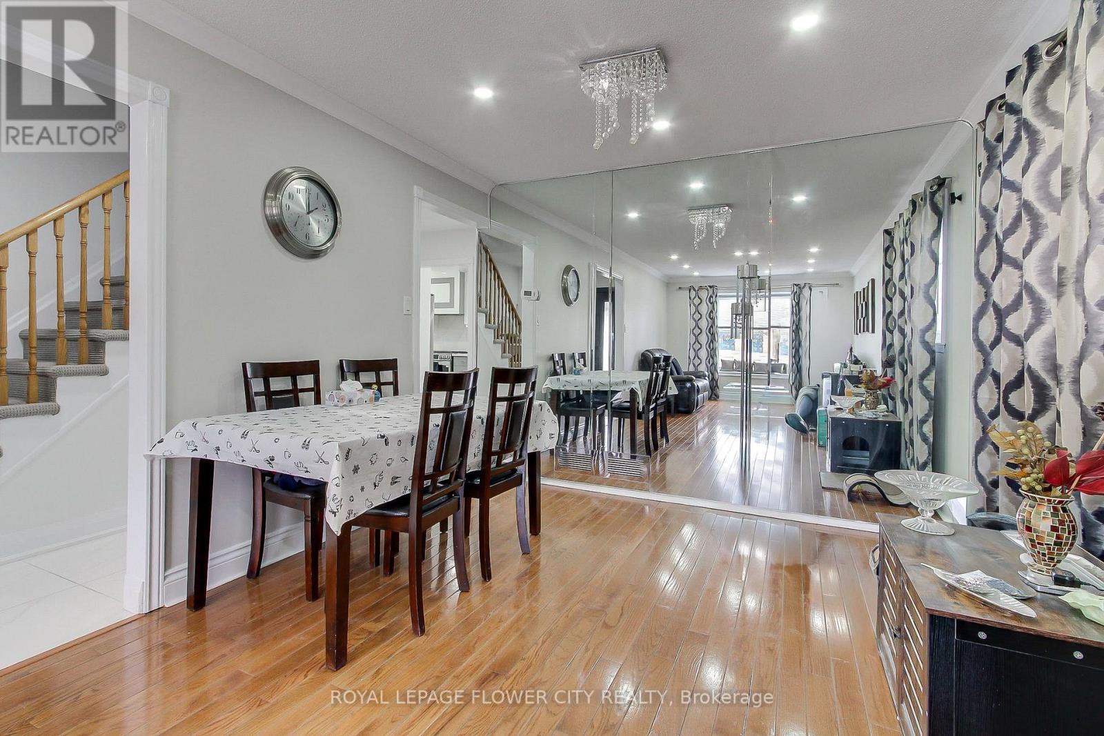 A dining room with a table set for six with a white tablecloth and chairs around it.