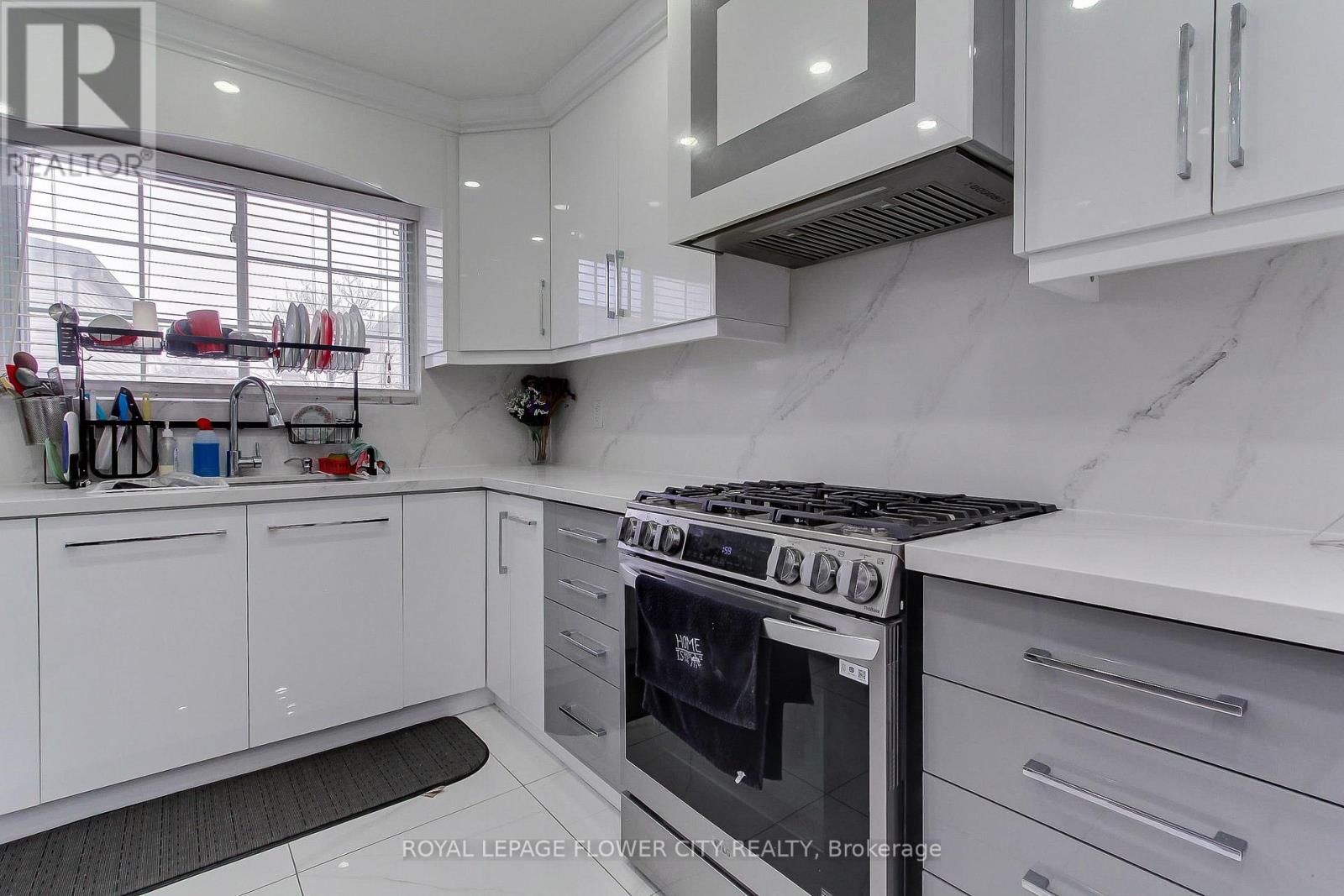 A modern kitchen with white cabinets and a stainless steel oven.
