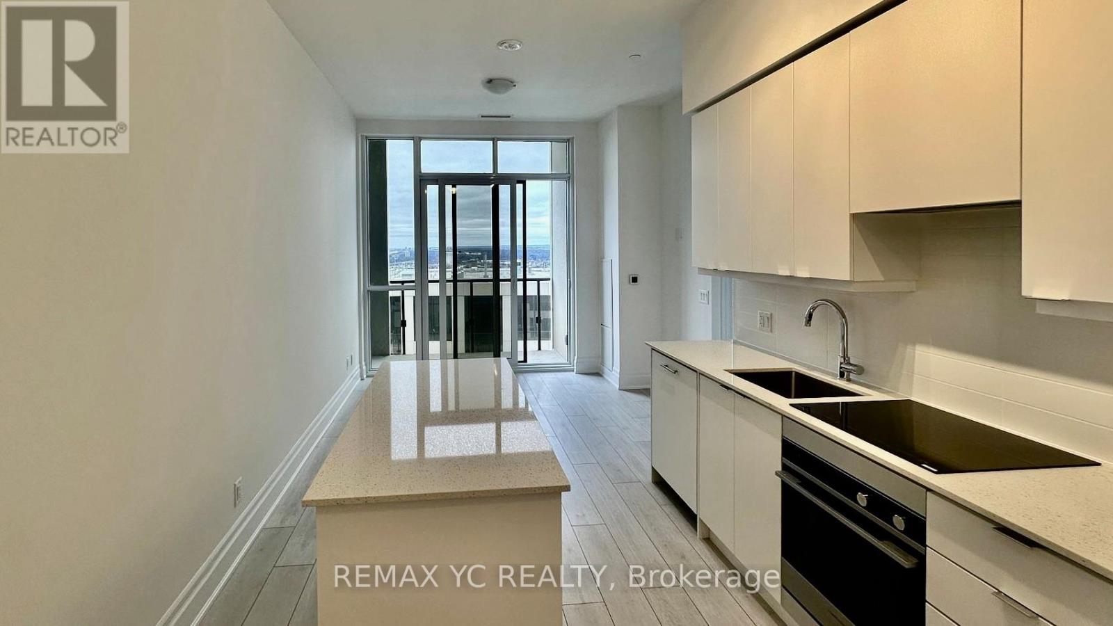 A kitchen with white cabinets and a sink.