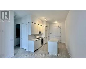 A white kitchen with a sink and a refrigerator.