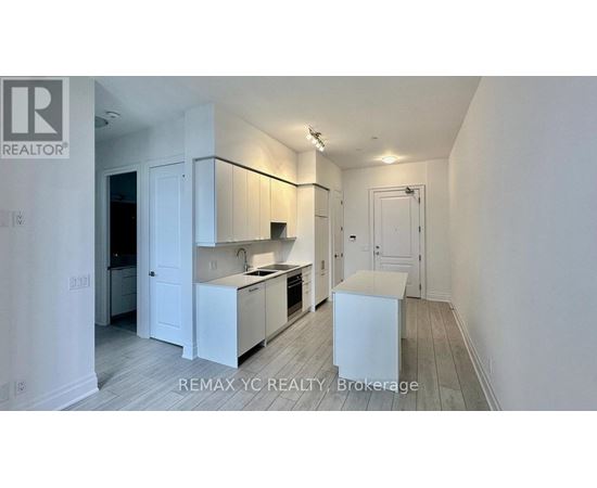 A white kitchen with a sink and a refrigerator.