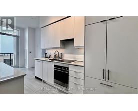 A modern kitchen with white cabinets and stainless steel appliances.